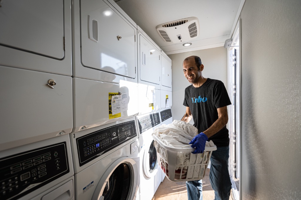 A Mission Accomplished volunteer happily handling laundry, showing the hands-on nature of our work